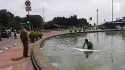 Petugas membersihkan busa yang mencemari kolam air mancur di bundaran patung kuda, Jakarta, Rabu (28/3). Kegiatan tersebut rutin dilakukan setiap busa-busa muncul di genangan air mancur. (Liputan6.com/Arya Manggala)