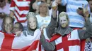 Fans Inggris mengenakan topeng Pangeran Harry, Ratu Elizabeth II dan suaminya Philip Mountbatten sebelum pertandingan antara Inggris dan Argentina di Tokyo, Jepang (5/10/2019). (AP Photo/Eugene Hoshiko)
