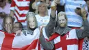 Fans Inggris mengenakan topeng Pangeran Harry, Ratu Elizabeth II dan suaminya Philip Mountbatten sebelum pertandingan antara Inggris dan Argentina di Tokyo, Jepang (5/10/2019). (AP Photo/Eugene Hoshiko)