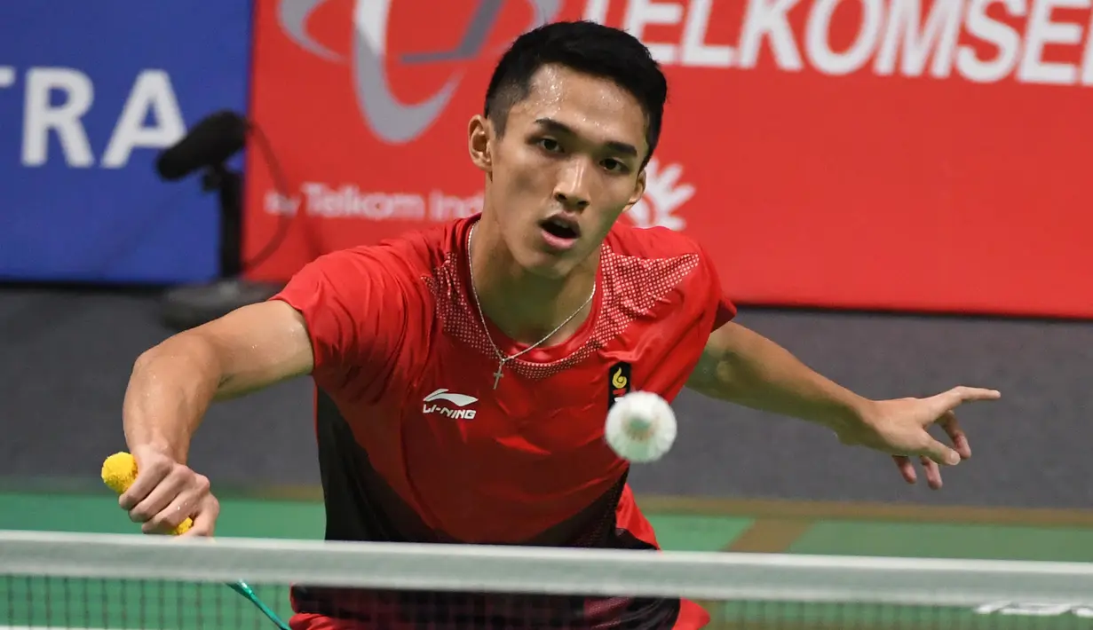 Pebulu tangkis Indonesia, Jonatan Christie mengembalikan kok saat bertanding melawan Kenta Nishimoto asal Jepang dalam semifinal tunggal putra Asian Games 2018 di Jakarta, Senin (27/8). Jonatan menang lewat rubber game. (SONNY TUMBELAKA/AFP)