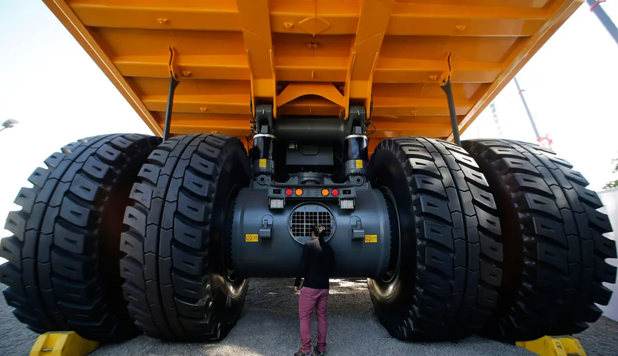 Pengunjung memerhatikan bagian belakang sebuah truk pertambangan yang dipamerkan dalam "Expomin 2014" di Santiago, Chili. (21/4/2014). (REUTERS/Ivan Alvarado)