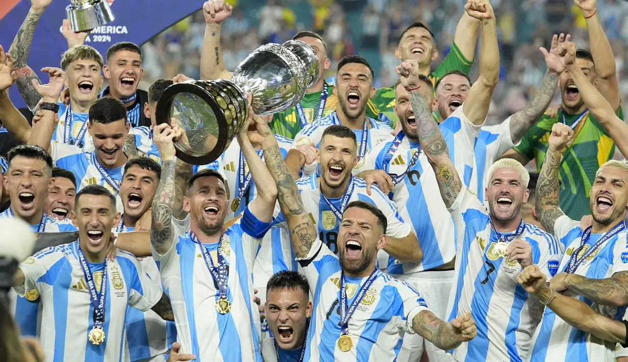Selebrasi para pemain Timnas Argentina, Lionel Messi dkk merayakan gelar juara Copa America 2024 di atas podium usai mengalahkan Timnas Kolombia 1-0 pada laga final di Hard Rock Stadium, Florida, Amerika Serikat, Minggu (14/7/2024). (AP Photo/Rebecca Blackwell)