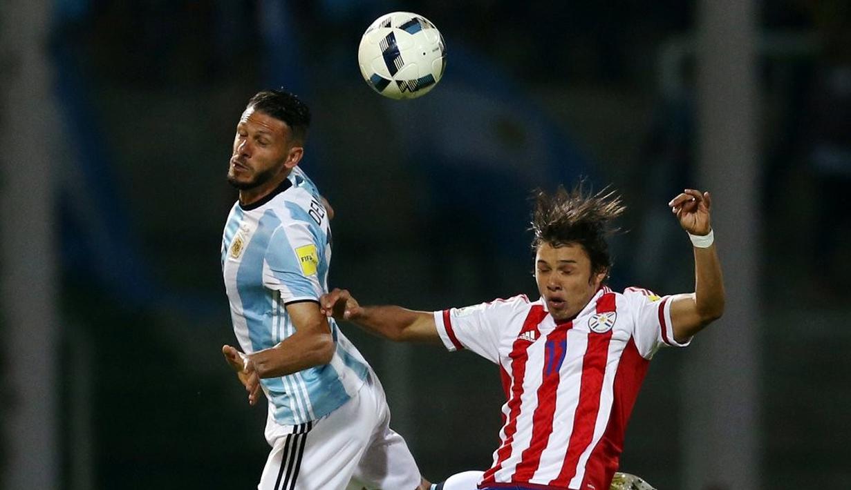 Perebutan bola antara pemain Argentina, Martin Demichelis, dan pemain Paraguay, Angel Romero, dalam laga Kualifikasi Piala Dunia 2018 zona Amerika Selatan, di Stadion Mario Kempes, Cordoba, Rabu (12/10/2016) pagi WIB. (Reuters/Marcos Brindicci)