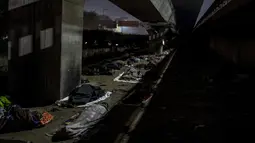 Tunawisma tidur di tempat terbuka di bawah jembatan penyeberangan pada malam yang dingin di New Delhi, Rabu, 28 Desember 2022. Angka sensus India tahun 2011 menunjukkan sekitar 47.000 penduduk kota itu tidur tanpa rumah, tetapi para aktivis mengatakan jumlahnya terlalu rendah dan bahwa New Delhi memiliki lebih dari 150.000 orang yang sulit tidur. (AP Photo/Altaf Qadri)