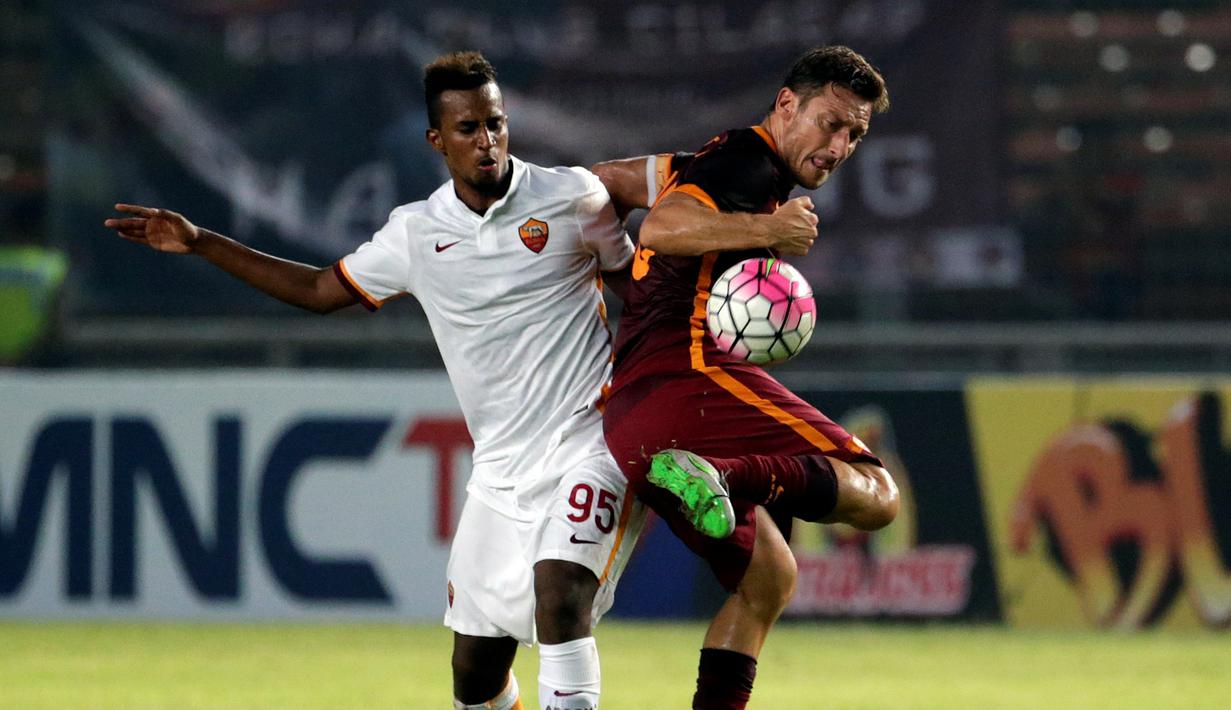 Francesco Totti (kanan) berebut bola dengan Elio Capradossi. (EPA/Mast Irham)