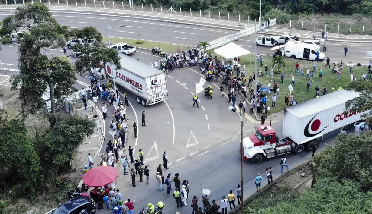 Truk-truk bantuan kemanusiaan untuk Venezuela menuju Jembatan Tienditas di perbatasan Kolombia-Venezuela, Cucuta, Kolombia, Kamis (7/2). Kedatangan bantuan ini disambut gembira oleh sekelompok migran Venezuela. (Edinson ESTUPINAN/AFP)