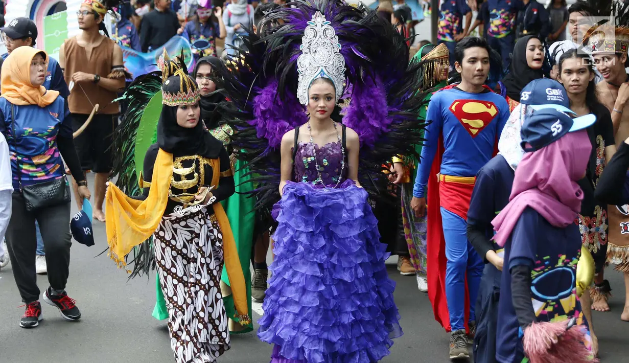 Sejumlah masyarakat mengenakan pakaian adat dan melakukan karnaval di jalan Pintu 1 Senayan, Jakarta, Minggu (24/9). Karnaval tersebut dilakukan dalam rangka HUT Gelora Bungkarno yang ke-55. (Liputan6.com/Angga Yuniar)