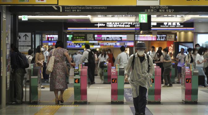 Seorang wanita yang mengenakan masker untuk membantu mengekang penyebaran virus corona COVID-19 keluar dari gerbang stasiun kereta api di Tokyo, Jepang, Jumat (6/8/2021). Tokyo dalam keadaan darurat virus corona COVID-19 sejak pertengahan Juli. (AP Photo/Kantaro Komiya)