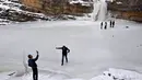 Para pengunjung berada air terjun Mirusha yang membeku di Lapceve, Kosovo (9/1). Cuaca bersuhu mencapai minus 20 derajat celcius membuat Air Terjun Mirusha dan kolam membeku. (AFP Photo/Armend Nimani)