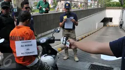 Saat reka ulang, Ali Tomket tampak memasuki parkiran Mall mengendarai motor, Senayan, Jakarta, Jumat (2/10/2015). Ali dijerat pasal 365 KUHP tentang Pencurian dengan Kekerasan dan pasal 338 tentang Pembunuhan. (Liputan6.com/Andrian M Tunay)