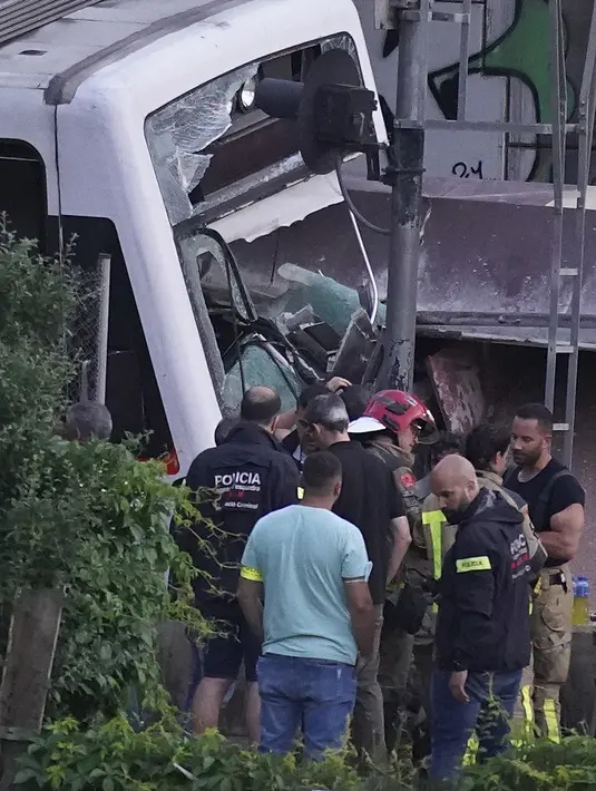 Layanan darurat bekerja di lokasi kecelakaan kereta api di Sant Boi dekat Barcelona, Spanyol, Senin, 16 Mei 2022. Kereta barang menabrak bagian depan kereta penumpang yang sedang keluar dari stasiun. (AP Photo/Joan Mateu Para)
