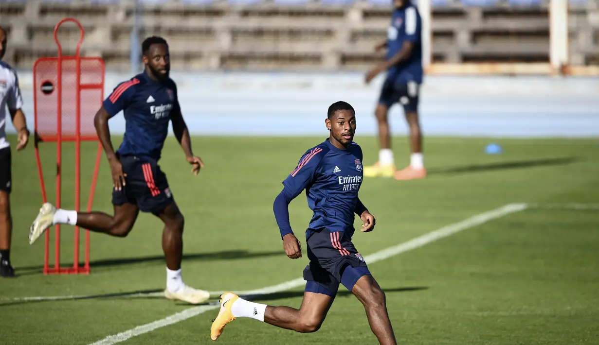 Pemain Lyon Moussa Dembele (kiri) dan Karl Toko Ekambi berlari saat sesi latihan di Stadion Restelo, Lisbon, Portugal, Selasa (18/8/2020). Lyon akan menghadapi Bayern Munchen pada pertandingan semifinal Liga Champions. (Franck Fife/Pool via AP)