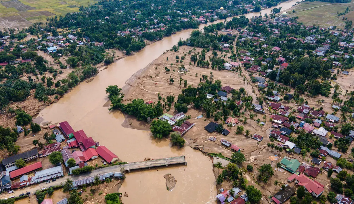 Diketahui, jembatan itu putus saat banjir deras melanda wilayah itu pada Rabu (26/11/2025), akibat hujan lebat yang terjadi dalam sepekan terakhir. Tampak foto udara menunjukkan jembatan yang rusak akibat banjir bandang di jalan utama yang menghubungkan Aceh dan Sumatera Utara di Meureudu, Kabupaten Pidie Jaya, Provinsi Aceh, pada Jumat 28 November 2025. (CHAIDEER MAHYUDDIN/AFP)