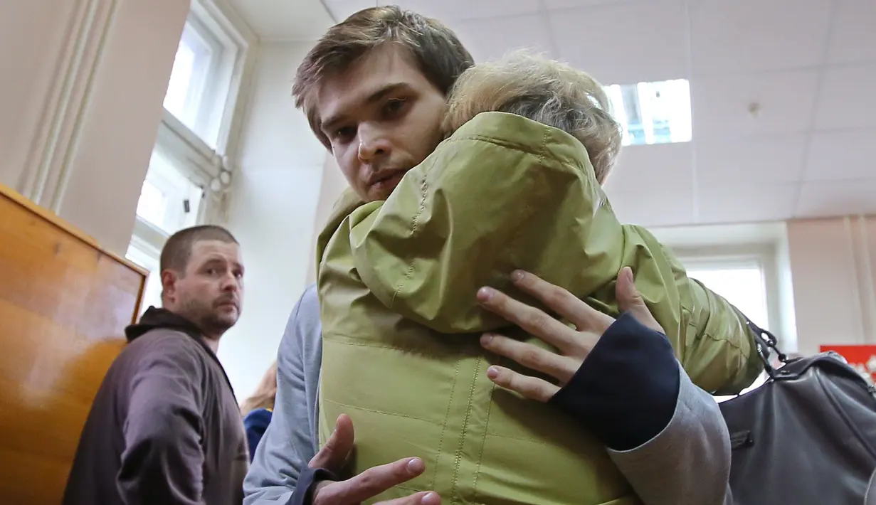 Blogger Rusia, Ruslan Sokolovsky, memeluk ibunya saat persidangan di Pengadilan Kota Yekaterinburg, Kamis (11/5). Pengadilan setempat memvonis Ruslan karena perbuatannya dianggap menghina pemeluk agama dan mengumbar kebencian. (Konstantin Melnitskiy/AFP)
