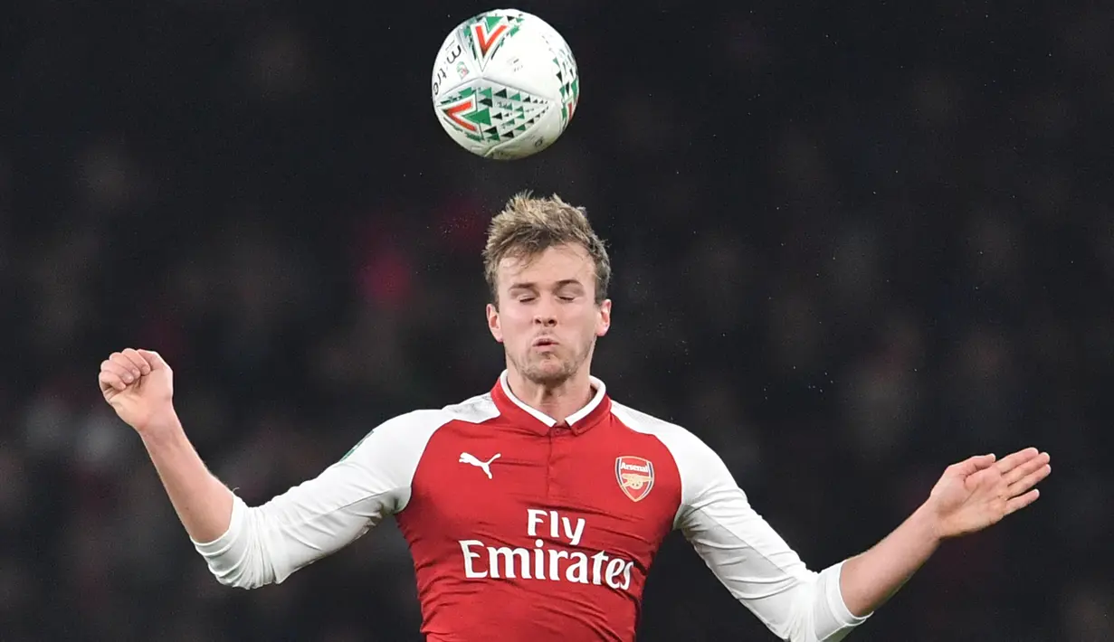 Bek Arsenal, Rob Holding berusaha mengontrol bola dengan kepalanya pada laga perempat final Piala Liga Inggris kontra West Ham United di Emirates Stadium, Selasa (20/12). Arsenal berhasil melaju ke babak semifinal setelah menang 1-0. (Ben STANSALL/AFP)