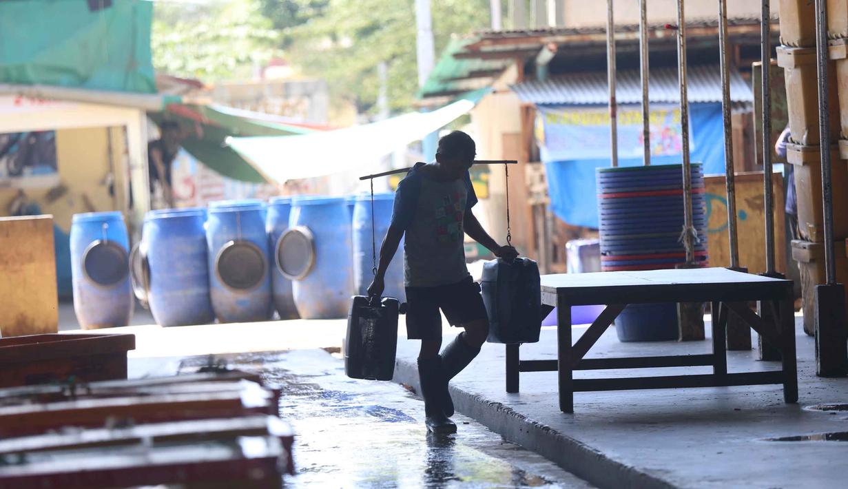Pedagang memikul jeriken berisi air bersih saat didistribusikan kepada pelanggan di Kawasan Muara Angke, Jakarta, Kamis (28/5/2026). (Kapanlagi.com/Budy Santoso)