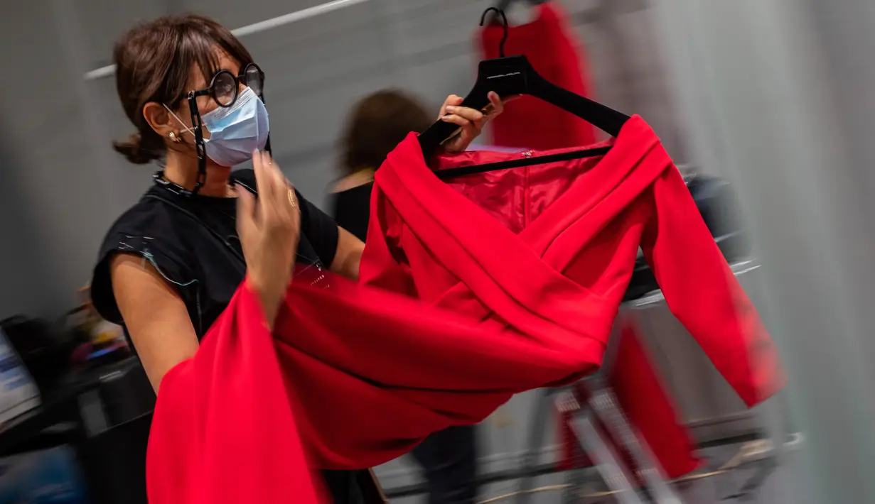 Staf desainer Spanyol, Hannibal Laguna bekerja di belakang panggung sehari sebelum dimulainya Mercedes-Benz Fashion Week di Madrid, Rabu (9/9/2020). Mode Spanyol berlangsung dari 10 - 13 September di bawah protokol kesehatan dan pedoman jarak sosial karena pandemi corona. (AP Photo/Bernat Armangue)