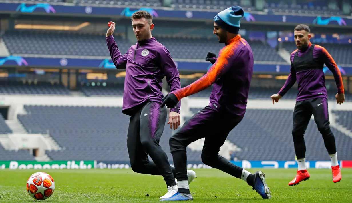 Pemain Manchester City Aymeric Laporte (kiri) dan Riyad Mahrez berebut bola saat berlatih jelang menghadapi Tottenham Hotspur pada leg pertama perempat final Liga Champions di Stadion Tottenham Hotspur, London, Inggris, Senin (8/4). (Reuters/John Sibley)