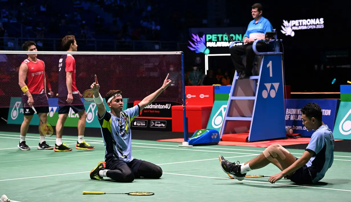 Selebrasi ganda putra Indonesia Fajar Alfian (kanan) dan Muhammad Rian Ardianto setelah membekuk wakil China dalam babak final Malaysia Open 2023 di Axiata Arena, Kuala Lumpur, Minggu (15/1/2023). Fajar/Rian sukses mengalahkan Liang Wei Keng/Wang Chang dan menyabet gelar juara pertama mereka di turnamen bulu tangkis level Super 1000. (AFP/Mohd Rasfan)