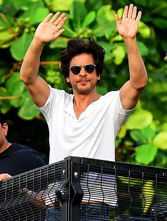 Shah Rukh Khan melambaikan tangan kepada penggemar pada perayaan ulang tahunnya ke-54 dari balkon rumah King of Bollywood itu di Mumbai, Sabtu (2/11/2019). Melalui balkon rumahnya, Shah Rukh Khan menyapa dan menyampaikan rasa terima kasihnya kepada penggemarnya yang sudah hadir. (Sujit Jaiswal/AFP)