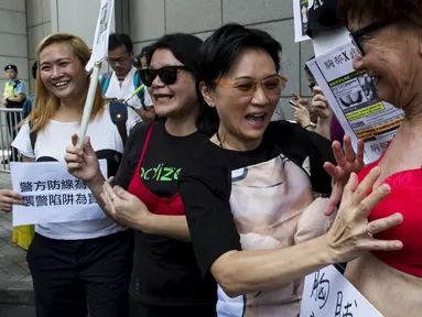 Pengunjuk rasa memakai bra di luar markas polisi di kawasan Wan Chai, Hong Kong, Minggu (2/8). Demo tersebut merupakan aksi simpati terhadap seorang perempuan yang di penjara karena dituduh menyerang polisi menggunakan payudaranya. (REUTERS/Tyrone Siu)
