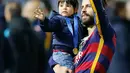 Pemain Barcelona Gerard Pique berselebrasi dengan putranya usai menundukkan River Plate 3-0, dalam final Piala Dunia Antar Klub 2015 di Stadion Internasional Yokohama, Jepang, Minggu (20/12). Barca menaklukan River Plate 3-0. (Reuters/Thomas PeterLivepic)
