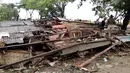 Warga memeriksa kerusakan rumah mereka setelah tsunami menerjang Pantai Carita, di perairan Banten, Minggu (23/12). Tsunami menerjang beberapa daerah di sekitar Selat Sunda pada Sabtu 22 Desember 2018 malam. (SEMI / AFP)