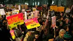 Sejumlah orang turun ke jalan, bergabung dalam aksi unjuk rasa di luar Downing Street, London, Senin (30/1). Mereka memprotes kebijakan Presiden AS Donald Trump yang melarang Muslim dari sejumlah negara memasuki Amerika Serikat. (AP Photo/Alastair Grant)