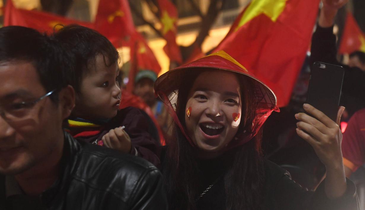 Seorang wanita merayakan keberhasilan Vietnam mengalahkan Qatar pada semifinal Piala AFC U-23 di Hanoi, Rabu (23/1/2018). Vietnam berhasil lolos ke final untuk menantang pemenang antara Uzbekistan dan Korea Selatan. (AFP/Hoang Dinh Nam)