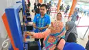 Petugas membantu calon penumpang melakukan transaksi di mesin penjual tiket di Stasiun Senen, Jakarta, Selasa (20/12). Jelang libur Natal dan tahun baru tiket Kereta Api sudah habis untuk keberangkatan Jateng dan Jatim. (Liputan6.com/Angga Yuniar)