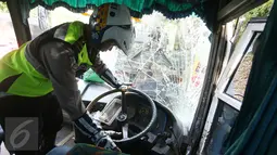 Petugas kepolisian menyelidiki sebuah bus PO Merdeka yang menabrak pohon di jalur Lingkar, Jawa Barat, Sabtu (2/7). Kecelakaan terjadi karena rem bus bernopol Z 7829 T itu tidak berfungsi, alias blong. (Liputan6.com/Immanuel Antonius)