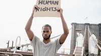 Ilustrasi HAM/ Hak Asasi Manusia (Photo by Lara Jameson: https://www.pexels.com/photo/man-in-a-gray-shirt-holding-a-human-rights-sign-8898590/)