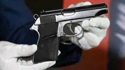 Pistol PP Walther yang digunakan Sean Connery dalam film James Bond pertama, "Dr. No" (1962) saat pratinjau pers di Beverly Hills, California, Selasa (23/11/2020). Properti film itu diperkirakan terjual sekitar Rp2,1 miliar hingga Rp2,8 miliar di Julien's Auctions pada 3 Desember. (Robyn Beck/AFP)