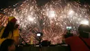 Penonton mengambil gambar pertunjukan kembang api dari Pandora-Pyrotechnie asal Perancis pada Kompetisi Pyromusical Internasional di Manila, Filipina, Sabtu (10/3). Acara yang menarik ribuan wisatawan ini sudah memasuki tahun ke-9. (AP/Bullit Marquez)