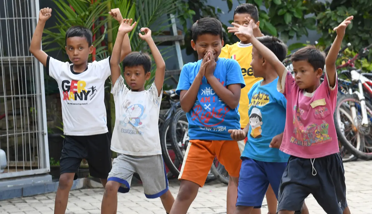 Sejumlah anak melakukan pemanasan di Padepokan Gajah, sebuah akademi swasta di Pringsewu, Kabupaten Lampung, Sumatera Selatan (7/11). Menjelang Asian Games 2018 dan Tokyo 2020, Indonesia siap mengirim atlet angkat besi tanguh. (AFP Photo/GOH Chai Hin)