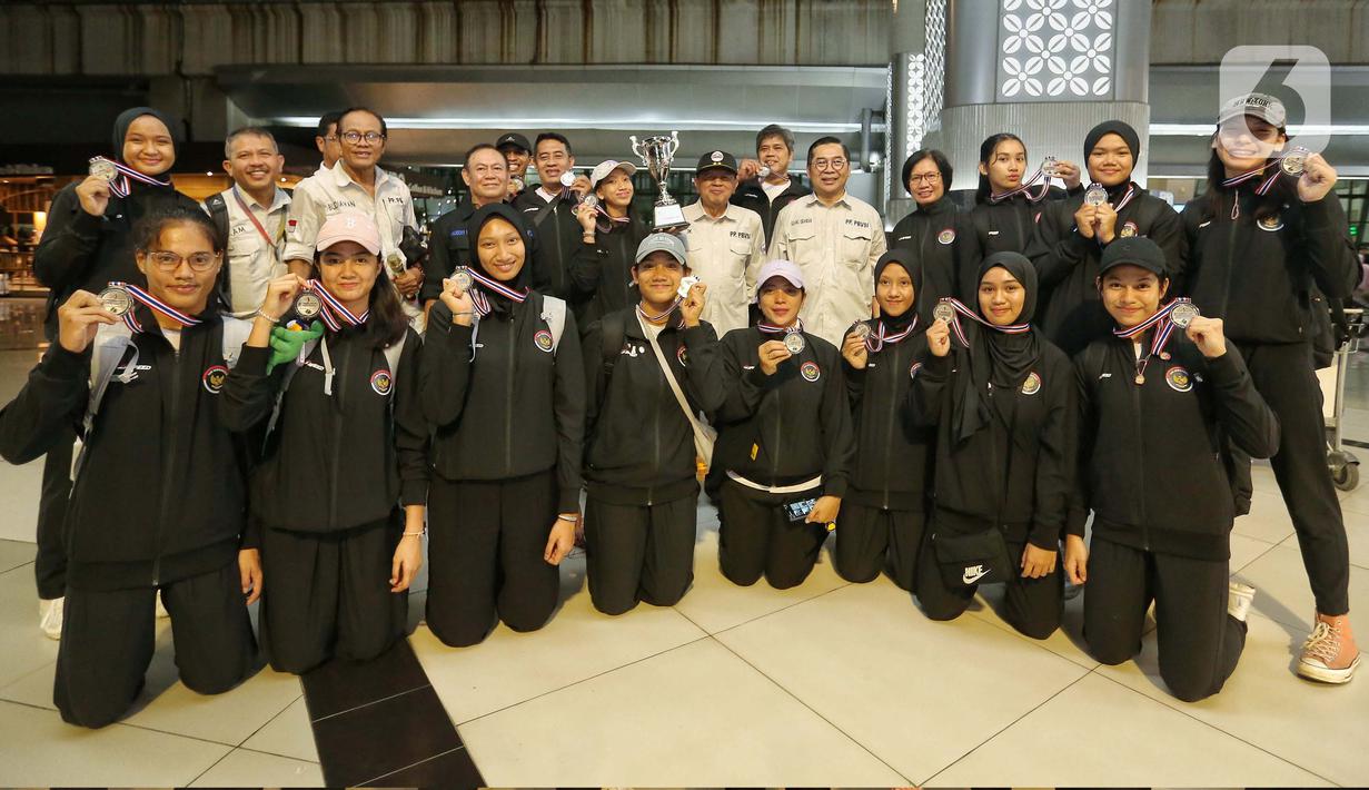 Wakil Ketua Umum Pengurus Pusat Persatuan Bola Voli Seluruh Indonesia (PP PBVSI), Irjen Pol (purn) Drs. Djoko Sardono (tengah) bersama Wakil Sekretaris Jenderal PBVSI, Gilang Iskandar serta pengurus PBVSI lainnya berfoto bersama saat menyambut kedatangan tim Voli Putri Indonesia U-18 di Bandara Soekarno Hatta, Tangerang, Banten, Jumat (14/6/2024). (Liputan6.com/Angga Yuniar)