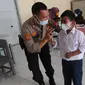 Anggota Polsek Cinere mendampingi murid kelas II saat vaksinasi covid-19 di SDI Al Hidayah, Depok, Selasa (25/1/2022). Mengantisipasi meningkatnya kasus Omicron, pemerintah mempercepat vaksin untuk lansia dan anak-anak, baik itu vaksin dosis pertama, kedua, maupun booster. (merdeka.com/Arie Basuki)