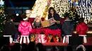 Ibu Negara AS, Michelle Obama membacakan dongeng bersama tokoh boneka Miss Piggy untuk anak-anak dalam acara menyalakan Pohon Natal Nasional di Taman Ellipse, dekat Gedung Putih, Washington, Kamis (3/12). (AFP PHOTO/Brendan SMIALOWSKI)