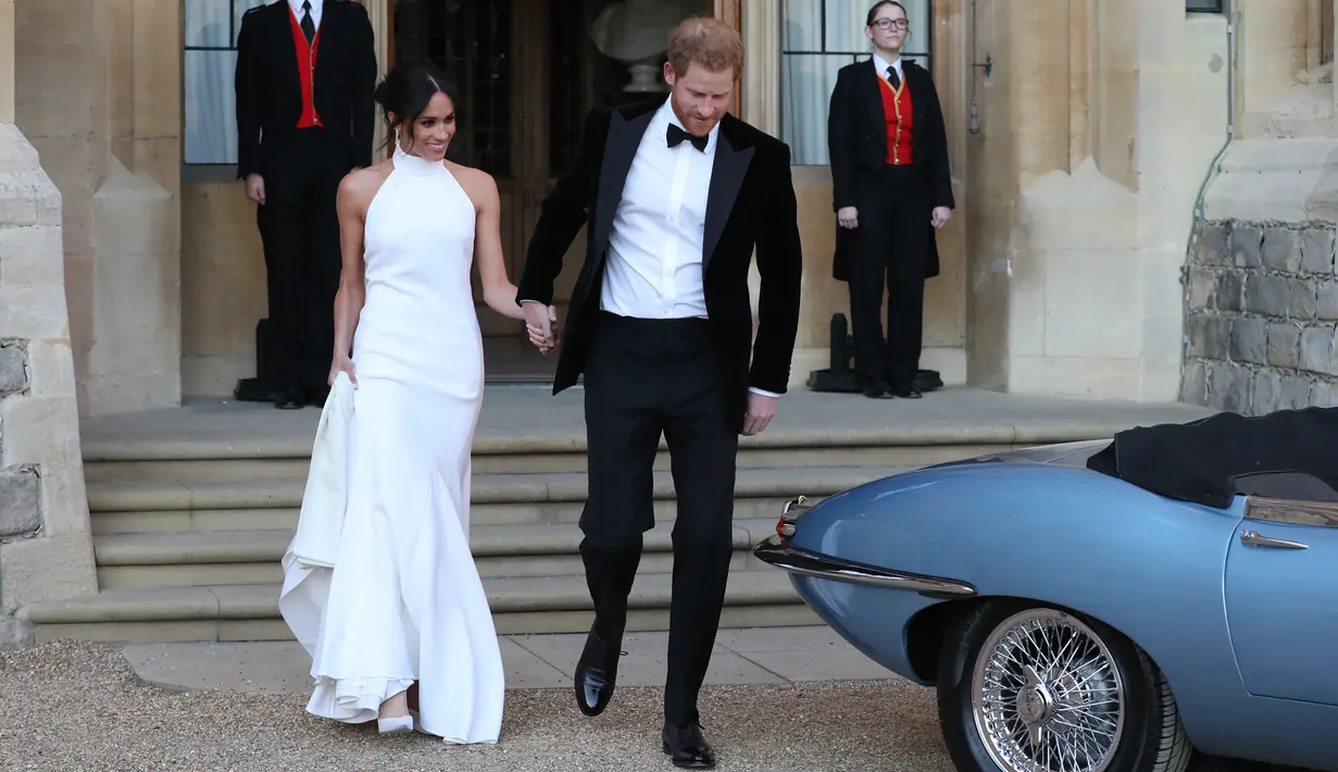 Pangeran Harry dan istrinya Meghan Markle bersiap meninggalkan Kastil Windsor dengan menggunakan mobil listrik Jaguar Classic E-Type Concept Zero menuju acara resepsi dekat Frogmore House (19/5). (AFP Photo/Pool/Steve Parsons)