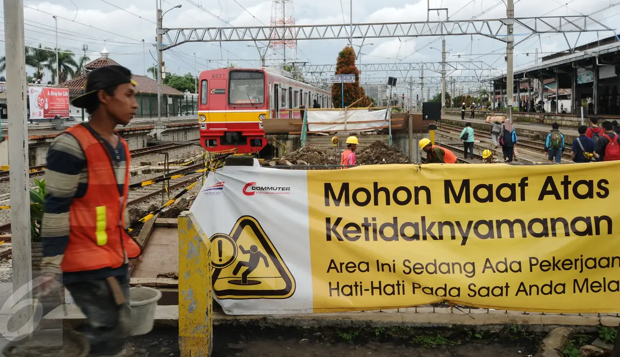Seorang pekerja melintas di depan proyek penambahan panjang peron 6 dan 7 Stasiun Bogor, Jawa Barat, Rabu (16/12/2015). Penambahan panjang peron dilakukan untuk lebih memberikan kenyamanan bagi pengguna KRL. (Liputan6.com/Helmi Fithriansyah)