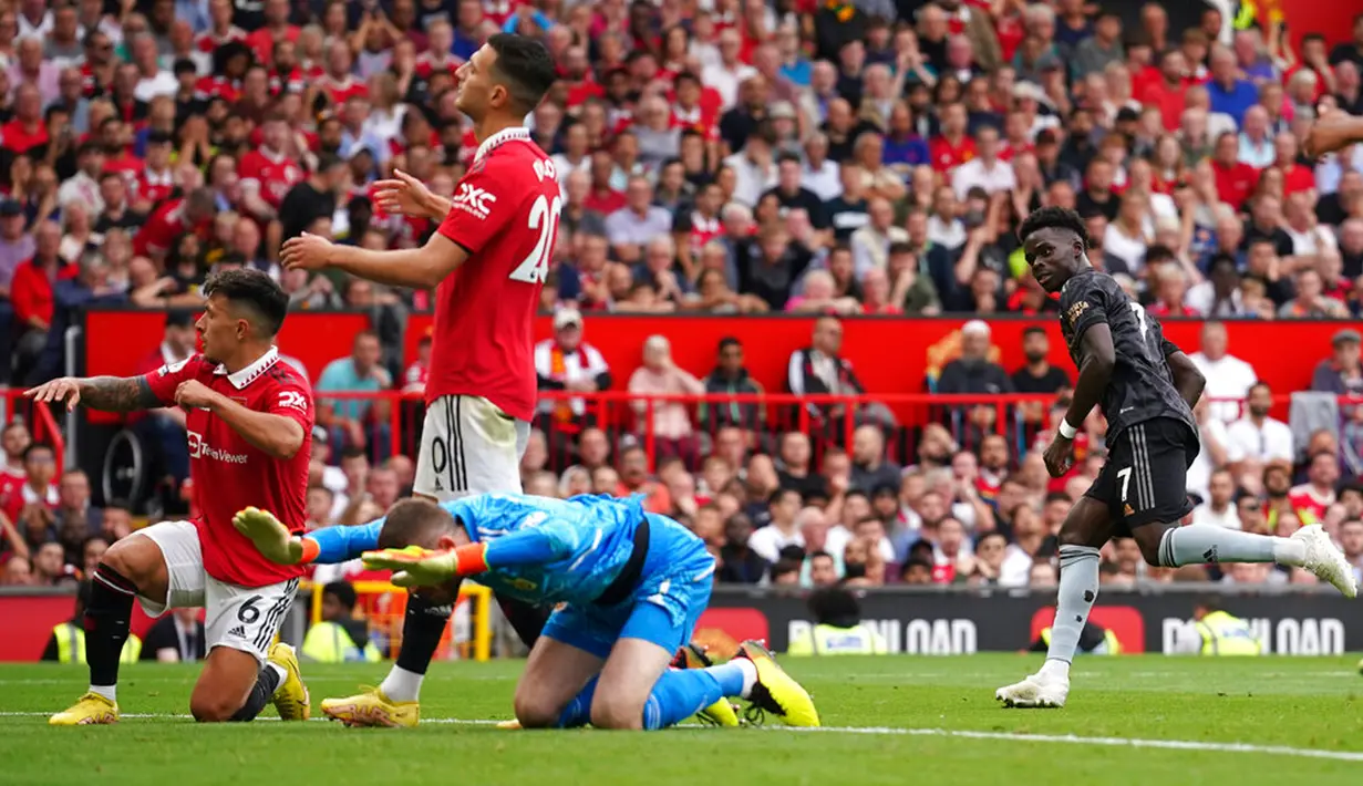 Pemain Arsenal Bukayo Saka (kanan) mencetak gol ke gawang Manchester United pada pertandingan sepak bola Liga Premier Inggris di Stadion Old Trafford, Manchester, Inggris, 4 September 2022. Manchester United menang atas Arsenal dengan skor 3-1. (AP Photo/Dave Thompson)
