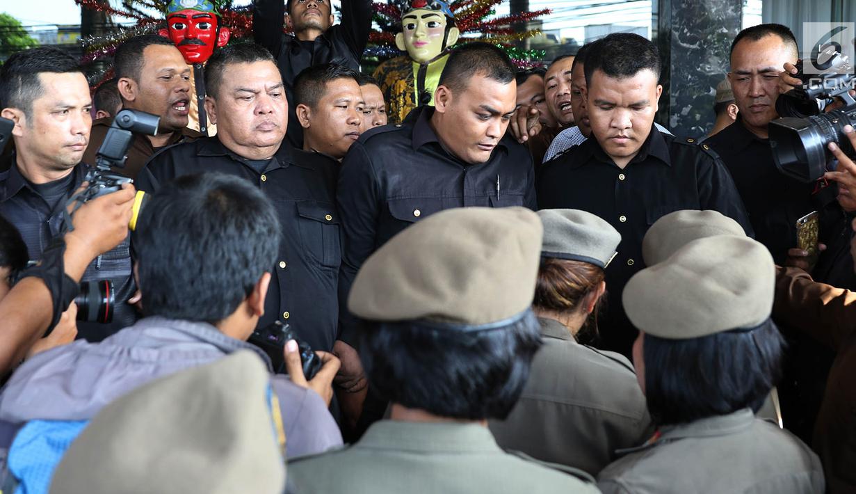 Ibu-ibu personel Satpol PP bersitegang dengan petugas keamanan di depan Hotel Alexis, Jakarta, Kamis (29/3). Ibu-ibu personel Satpol PP ini bertugas untuk memastikan tidak ada kegiatan usaha apapun di Hotel Alexis. (Liputan6.com/Immanuel Antonius)