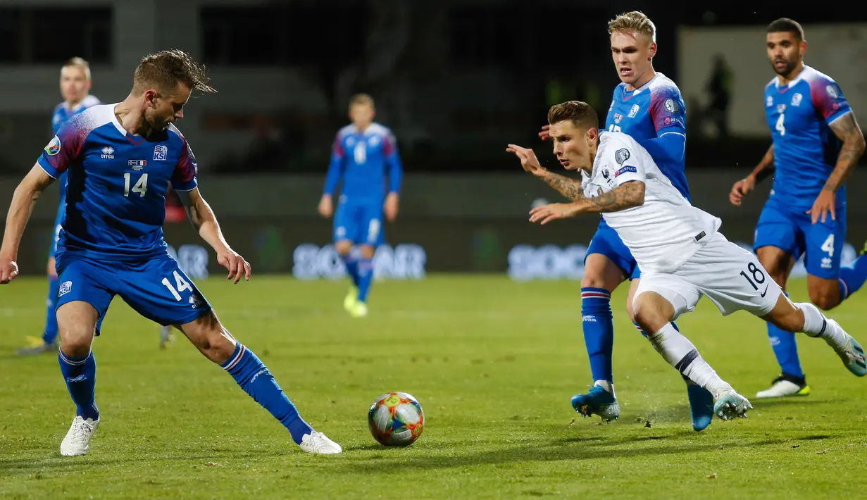 Bek timnas Prancis, Lucas Digne berebut bola dengan pemain Islandia, Kari Arnason dalam laga lanjutan Grup H Kualifikasi Piala Eropa 2020. di Stadion Laugardalsvollur, Reykjavik, Jumat (11/10/2019). Timnas Prancis harus susah payah mengalahkan Islandia 1-0. (AP/Brynjar Gunnarsson)