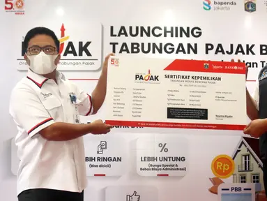 Direktur Ritel dan Syariah Bank DKI Babay Parid Wazdi (kiri) memberikan Sertifikat Kepemilikan Tabungan Pajak kepada Wakil Kepala Bapeda DKI, Elvarinsa pada peluncuran Tabungan Pajak Bank DKI di Jakarta (30/3/2022). Melalui Tabungan Pajak, wajib pajak dapat menabung terjadwal. (Liputan6.com/HO/BDKI)