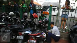 Petugas Dishub mengembosi motor yang parkir di sepanjang trotoar kawasan Kebon Sirih, Jakarta, Rabu (18/1). Puluhan motor diamankan serta digembosi dalam penertiban tersebut karena menutupi jalur pedestrian. (Liputan6.com/Immaniel Antonius)