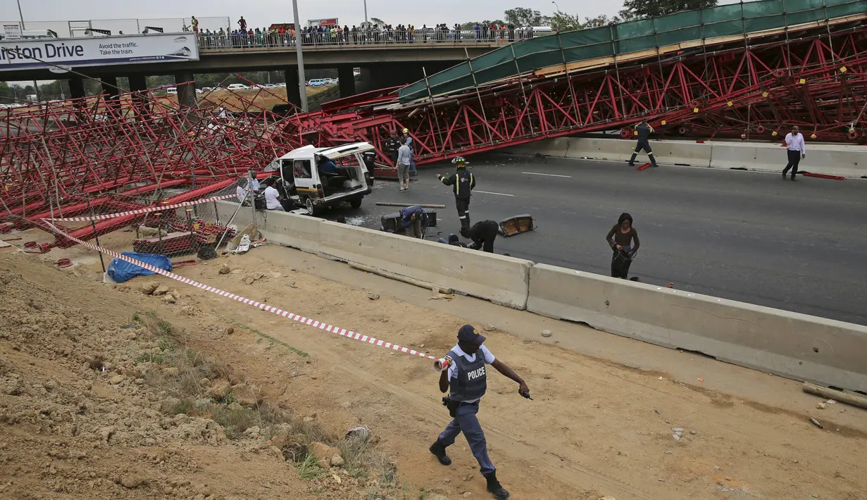 Petugas berada di lokasi ambruknya perancah atau scaffolding jembatan yang sedang dibangun di jalan tol M1 menuju Sandton, Afsel, Rabu (14/10). Kejadian itu menewaskan dua orang dan 20 lainnya cedera, menurut kantor SAR lokal. (REUTERS/Siphiwe Sibeko)