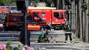 Petugas penyelamat disamping jasad seorang pria usai serangan terhadap van polisi di jalan Champs Elysees, Paris, Senin (19/6). Pria 31 tahun tersebut tewas, sementara pihak kepolisian yang menjadi target tak terluka sedikitpun. (Thomas SAMSON/AFP)