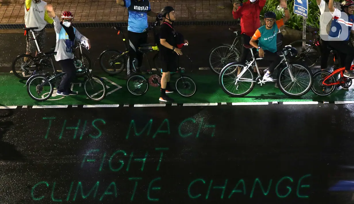 Pegiat bersepeda dan aktivis pecinta lingkungan saat aksi gowes Kelap Kelip Jakarta Night Ride #NOP26 di Kawasan Dukuh Atas, Jalan Jenderal Sudirman, Jakarta, Jumat (26/11/2021). Aksi bertujuan untuk mendorong penggunaan sepeda sebagai solusi transportasi nol emisi. (Liputan6.com/Helmi Fithriansyah)