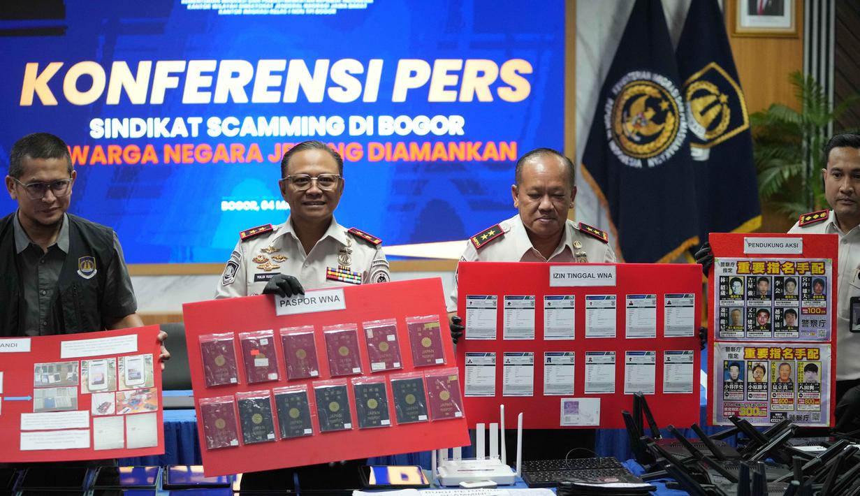 13 WNA Jepang tersebut terjaring operasi pengawasan keimigrasian. Tampak dalam foto, petugas Imigrasi menunjukkan barang bukti yang disita dari warga negara Jepang yang diduga terlibat dalam sindikat penipuan daring (online), di Bogor, Jawa Barat, Rabu 4 Maret 2026. (AP Photo/Achmad Ibrahim)
