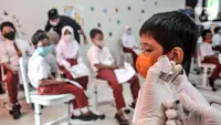 Petugas kesehatan menyiapkan vaksin COVID-19 saat akan menyuntik seorang murid di SDN Cempaka Putih Timur 03 Pagi, Jakarta, Selasa (14/12/2021). Pemerintah mulai melakukan vaksinasi COVID-19 kepada anak usia 6-11 tahun. (merdeka.com/Iqbal S. Nugroho)